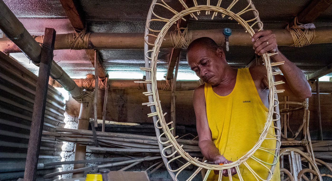 July 2017. Owner, Idevlino Dagot, making rattan furniture at Dagot Rattan Crafts and Furniture. Puerto Princesa, Palawan, Philippines. Photograph by Jason Houston for USAID