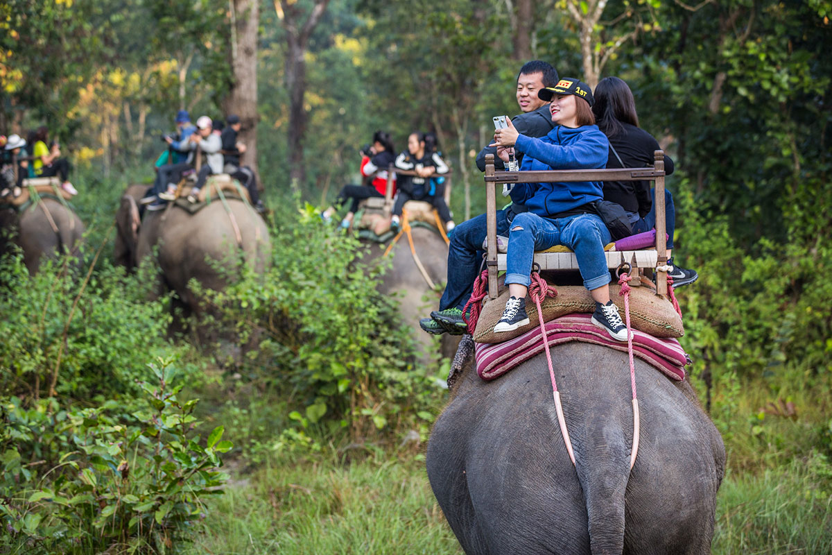 November 2017. Tourists take jungles safaris on elephants in hopes of viewing a Greater One-horned Rhinoceros (Rhinoceros unicornis). Bagmara Buffer Zone. Sauraha, Chitwan District, Nepal. Photograph by Jason Houston for USAID