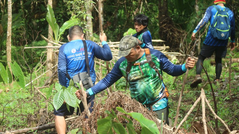 A group of community-based forest protection officers in Bago City, Philippines, dismantle an illegally established hut. Photo Credit: Noel P. Labutap/USAID Safe Water Project