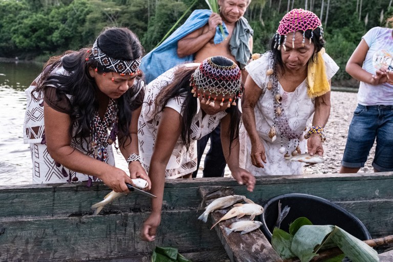 Maritza Bolivar (left) and Nelia (right) with fish caught and being prepared for a traditional smoked-fish community feast in Peru. Photograph by Jason Houston for USAID.