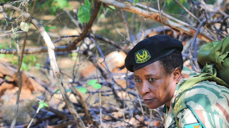 A women warden for Lower Zambezi National Park in Zambia looks off into the forest. Photo credit: David Nangwenya for USAID ILRG