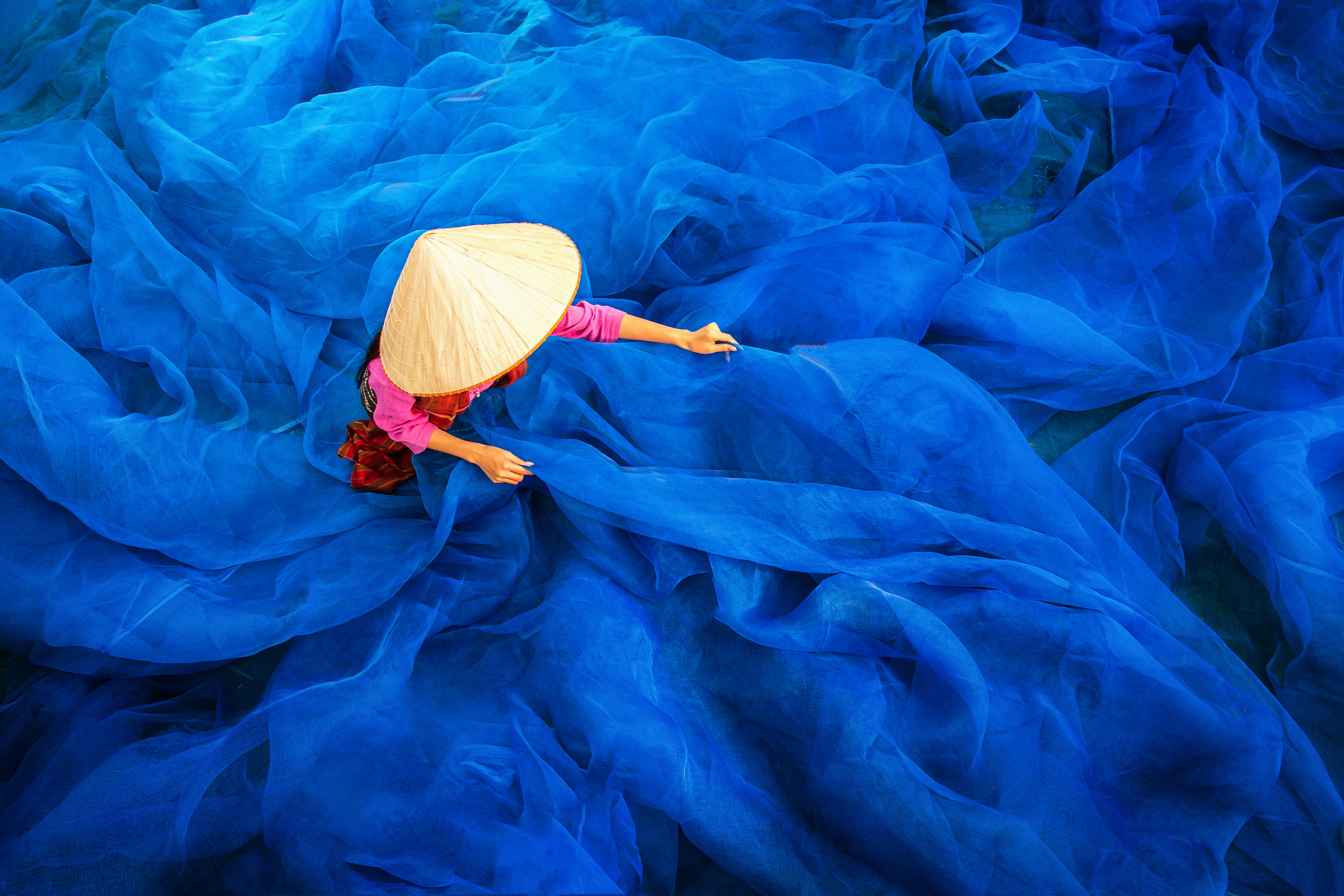 Beautiful Woman Fisherman Repairing Fishing Nets. Credit: Tong Stocker